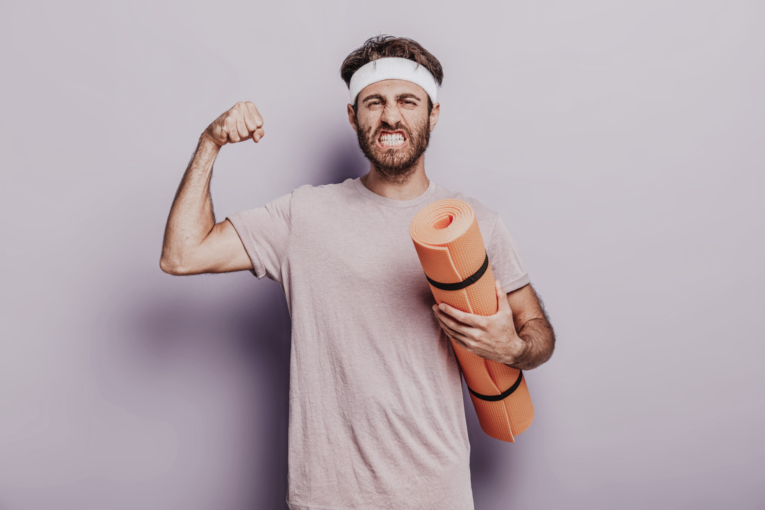 Motivierter, lustiger Mann mit Yoga/Fitnessmatte im Studio von Dodo Stehlo - Sympathisches Training für Kraft, Beweglichkeit und pure Lebensfreude in Pfäffikon SZ.